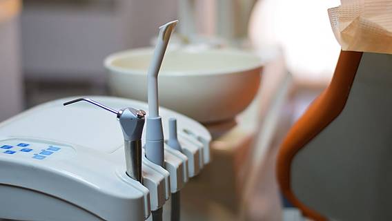 Symbolfoto: Nahaufnahme der Ausstattung in einer Zahnarztpraxis - ein Waschbecken und eine Halterung mit Zahnarzt-Bohrer und -sauger