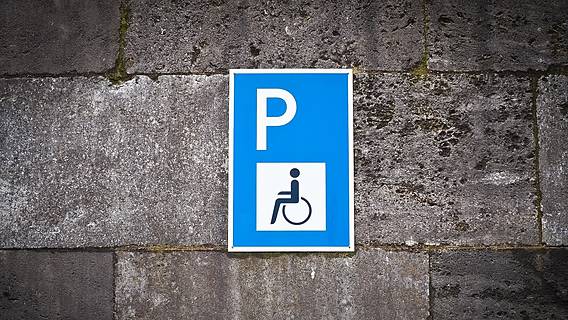 Das Foto zeigt ein Schild, das auf einen Behindertenparkplatz verweist.