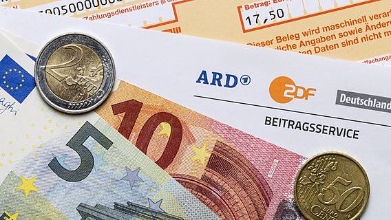 Symbolfoto: Ein Brief des ARD-Beitragsservices; darauf liegt 17,50 Euro in Scheinen und Münzen. Darunter liegt ein Überweisungsträger.