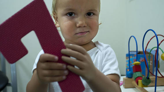 Das Bild zeigt ein Kind mit einer Handprothese
