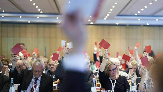 Blick in den Tagungssaal: Die Ordentlichen Delegierten des VdK-Bundesverbandstag halten ihre Stimmkarten hoch
