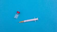 Das Foto zeigt eine Injektionsspritze und ein Fläschchen mit einer Impfdosis