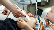 Eine Ultraschallärztin macht einen Ultraschall der Bauchhöhle des Kindes