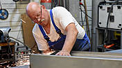 Symbolfoto: Ein älterer Arbeitnehmer an seinem Arbeitsplatz als Schlosser