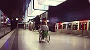 Symbolfoto: eine Frau im Rollstuhl ist auf einem Bahnsteig am Hamburger Bahnhof unterwegs.