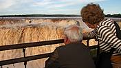 Ein älteres Paar schaut auf einen Wasserfall.