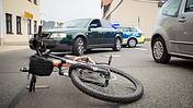 Das Bild zeigt ein Fahrrad, das nach einem Unfall auf der Straße liegt.