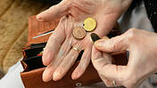 Symbolbild: Hand einer alten Person hält Cent-Münzen.