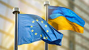 Symbolfoto: Eine EU-Flagge und eine ukrainische Flagge wehen nebeneinander im Wind