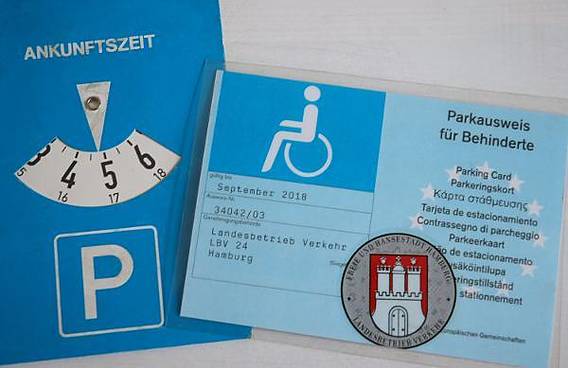 Symbolfoto: Ein Hamburger Parkausweis für Behinderte mit einer Parkscheibe.