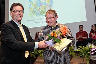Ortsverbandschef Jochen D. Lentzsch (links) überreicht einen Preis an den Künstler Albert Braig.