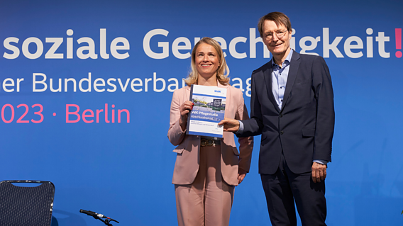 Auf dem Foto sieht man Verena Bentele (links) und Karl Lauterbach (rechts) auf einer Bühne stehen. Sie halten beide die VdK-Pflegestudie in der Hand.