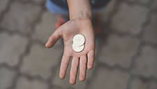 Hand mit einer Münze darin