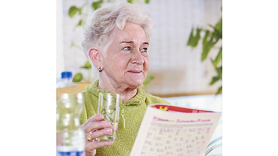 Ein ältere Frau trinkt Wasser.