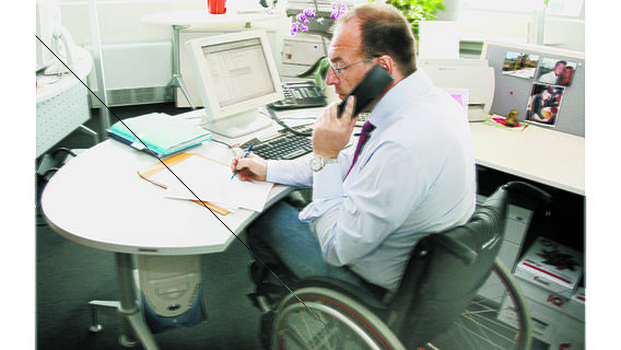 Arbeitnehmer mit Rollstuhl im Büro