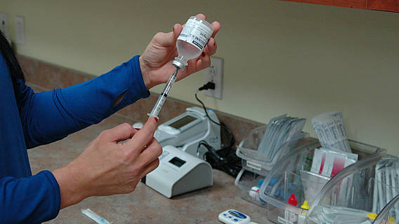 Eine Krankenschwester füllt eine Spritze mit einem Medikament.