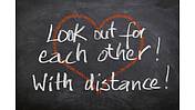Auf einer Tafel steht: Look ot for each other! With distance!