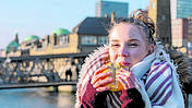 Eine junge Frau isst unterwegs einen Snack.