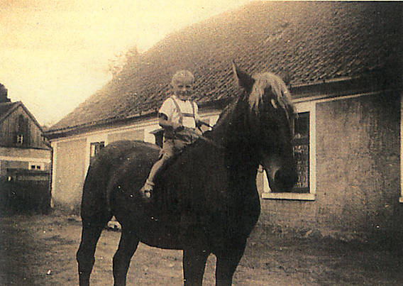 Schwarzweißfotografie mit Reiter, Pferd und Haus in Ostpreußen