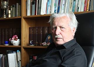 Arno Surminski, im Hintergrund sein Bücherregal