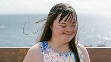 Foto einer jungen Frau mit Down-Syndrom an der Küste