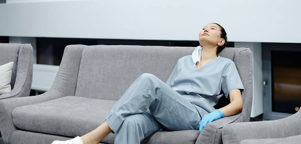 Foto einer Krankenschwester müde auf einem Sofa