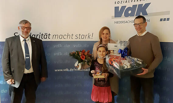 Foto: Landesvorsitzender Friedrich Stubbe begrüßt Grit Morbitzer mit ihrem Mann Bastian und Tochter Lea Marie als 100.000. Mitglied im VdK-Landesverband Niedersachsen-Bremen