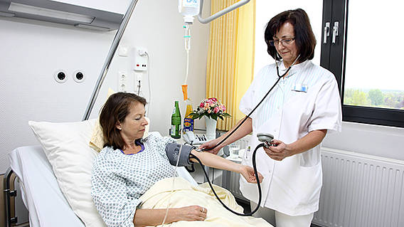 Symbolfoto: Eine Krankenschwester misst einer Patientin im Krankenhaus den Blutdruck.