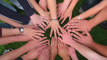 Symbolfoto: Viele Hände bilden gemeinsam einen Kreis