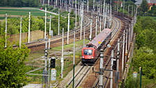 Symbolfoto: Ein Zug fährt auf Schienen durch eine Landschaft