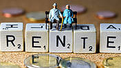 Symbolfoto: Buchstabenwürfel bilden das Wort "Rente", darauf sitzen kleine Figürchen von Senioren