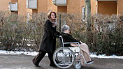 Symbolfoto: Eine Frau schiebt ältere Frau im Rollstuhl