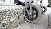 Symbolfoto: Rad eines Rollators oder Rollstuhls scheitert an einer Bordsteinkante