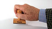 Symbolfoto: Ein Männerarm hält einen Stempel mit der Aufschrift "Rente"