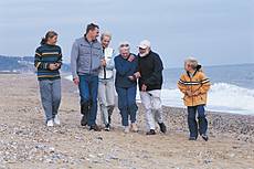 Symbolfoto: Eine Familie geht am Strand spazieren