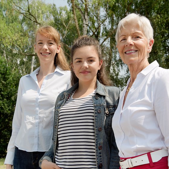 Frauen aus drei Generationen Drei Frauen lächeln gemeinsam in die Kamera: Eine jüngere, eine Teenagerin und eine ältere Frau.