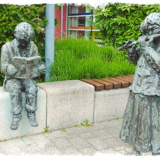 Hänsel und Gretel heißen die beiden Statuen vor der Bücherei. Ein lesender Junge und ein Mädchen das Flöte spielt. Dies sind die Arbeit des französischen Künstlers Alexandre Garcia.